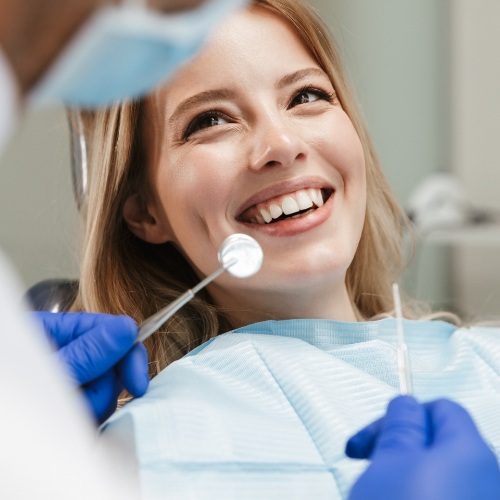 Woman smiling at dental team member during dental checkup