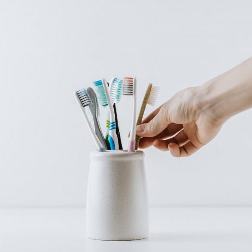 Hand reaches for brush in holder