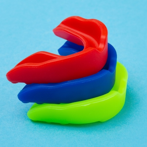 Green blue and red mouthguard stacked on top of each other