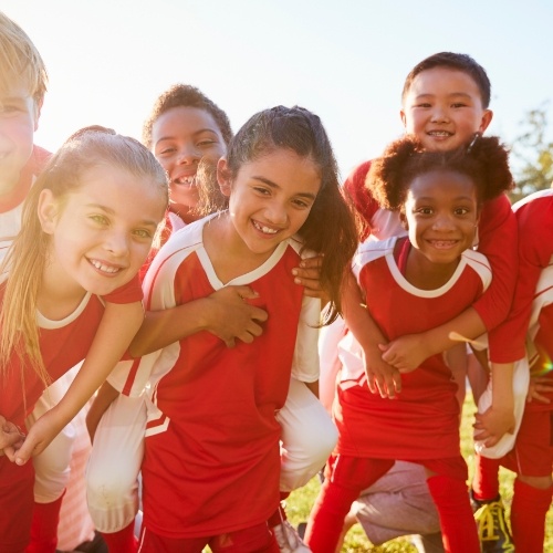 Smiling group of kids in matching red soccer uniforms