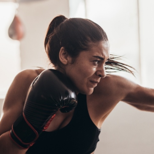 Woman wearing boxing gloves punching