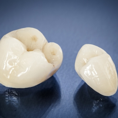 Two dental crowns against dark blue background