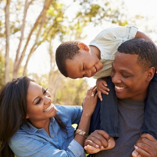 Mother father and toddler laughing together outdoors