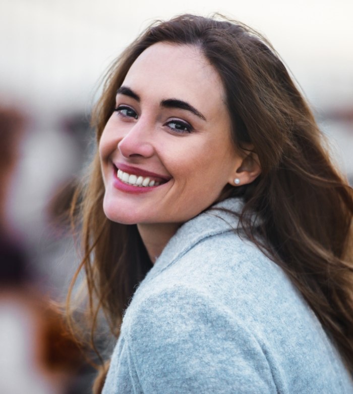 Woman smiling over her shoulder after a cosmetic gum lift in Norman