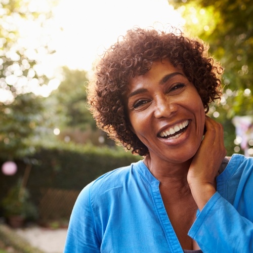 Woman in blue blouse smiling outdoors