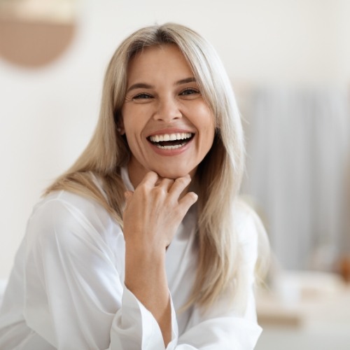 Older woman in white blouse grinning