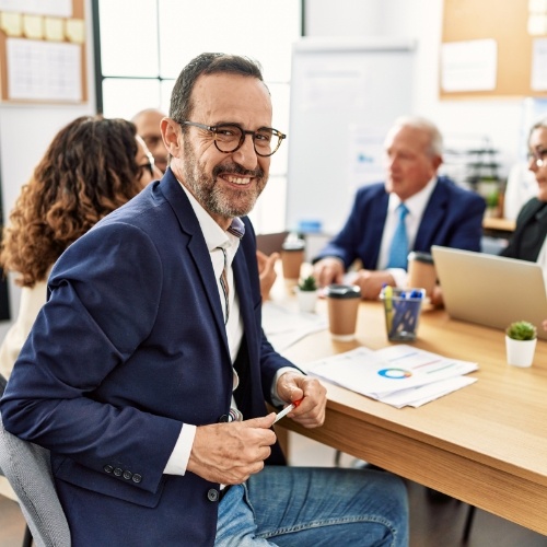 Man in business casual attire smiling during business meeting