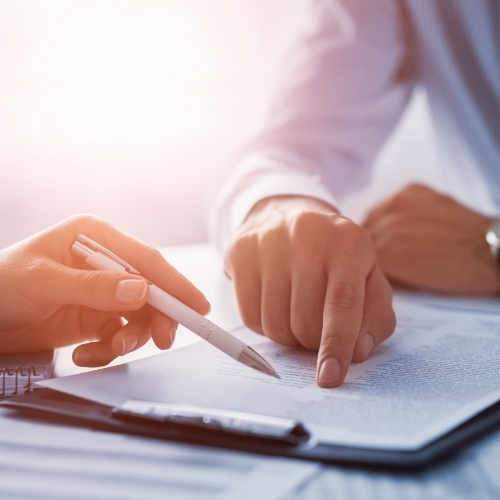 Person showing another person where to sign on a paper form