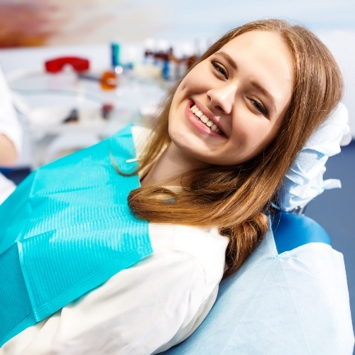 Young woman smiling while sitting in dental chair