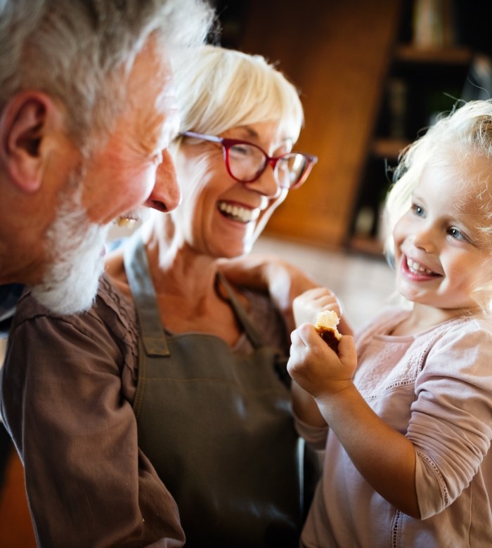 Senior man and woman with dentures in Norman playing with their grandchild