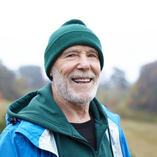 Smiling man wearing green beanie outdoors