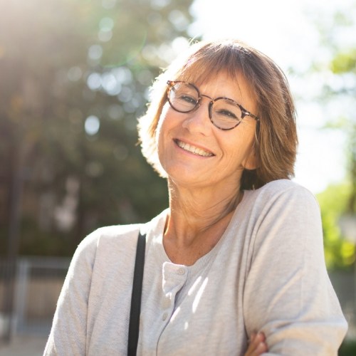 Woman in white blouse smiling outdoors