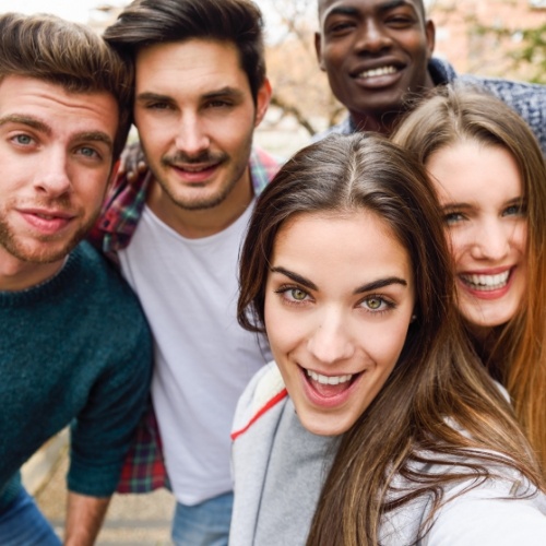 Five young adults taking a group selfie