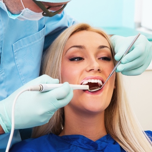 Dentist examining a patient's mouth with intraoral camera in Norman