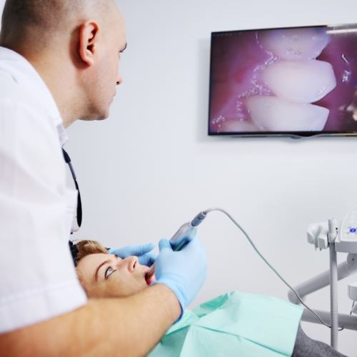 Dentist using intraoral camera to examine a patient's mouth