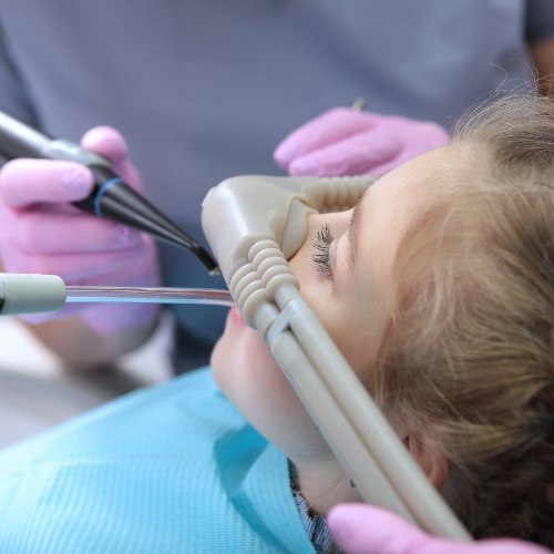 Young girl in dental chair receiving dental treatment with nitrous oxide