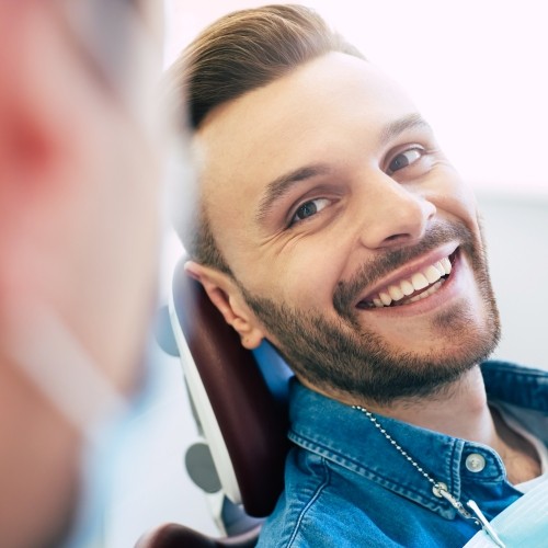 Young man smiling at his cosmetic dentist