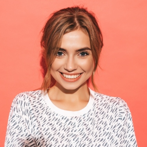 Smiling young woman in front of red orange background