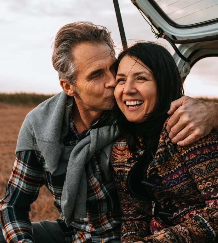 Man kissing smiling woman with dental veneers in Norman