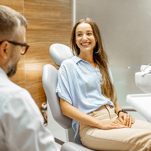 Smiling patient talking to cosmetic dentist about veneers