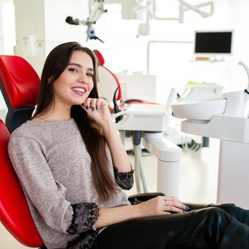 Woman in patient’s chair smiling and tilting her chin