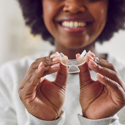 Woman holding a customized whitening tray