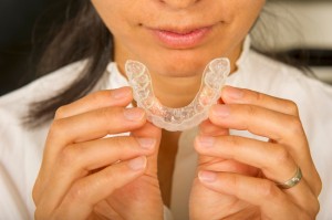Woman gets ready for bed by placing her mouthguard