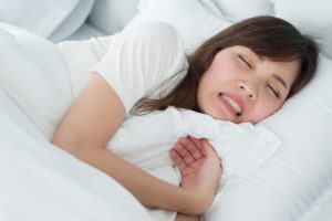 stressed person grinding their teeth while asleep