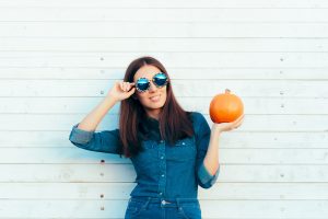 Woman smiling and holding pumpkin