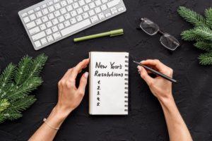 woman writing new year’s resolutions