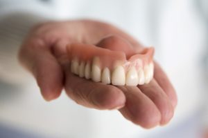 Hand holding model for soaking dentures