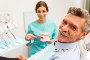 Older man at dental checkup with dentures