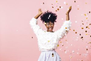 Woman throwing confetti to celebrate her healthier smile