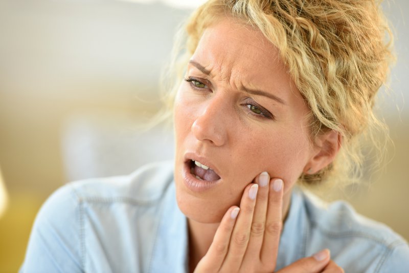 person clutching their jaw in pain