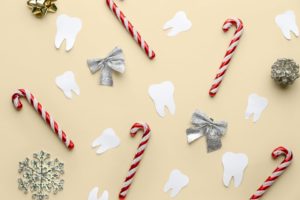 Tooth shaped cutouts on a yellow background with holiday decorations