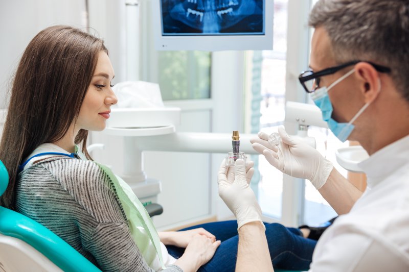 A woman talking to her dentist at a dental implant consultation